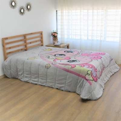 Cama com edredão cinza claro com desenhos cor de rosa e amarelos numa divisão clara