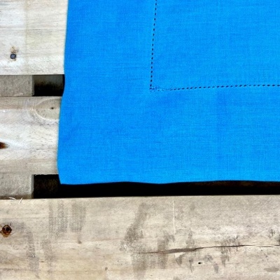 Tecido azul com costura sobre madeira rústica