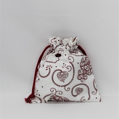 Saco de tecido branco com cordão vermelho e padrões castanhos