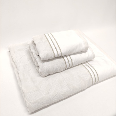 Conjunto de três toalhas brancas com linhas cinzentas e padrão texturizado empilhadas
