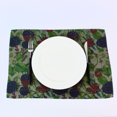 Jogo americano com frutas silvestres, prato branco, garfo e faca