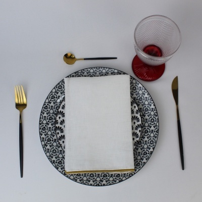 Conjunto de loiça floral a preto com talheres pretos e dourados e copo com base vermelha