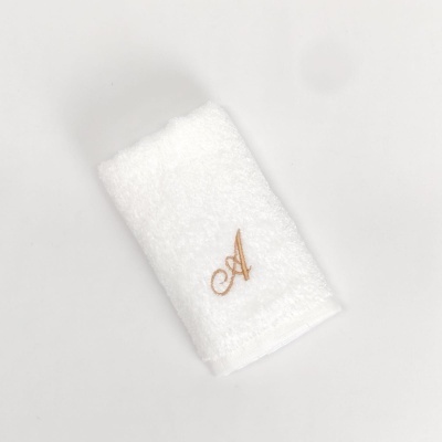 Toalha branca felpuda com bordado da letra A castanha