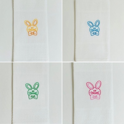 Toalhas brancas com bordados de coelhos coloridos