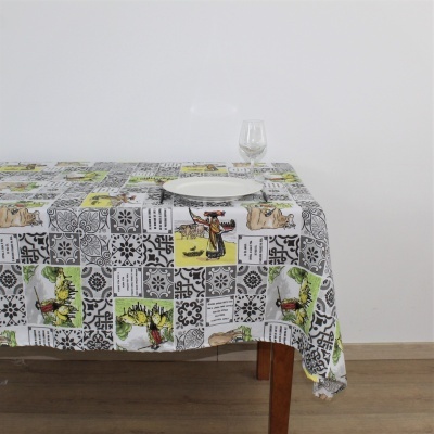 Toalha de mesa com padrão colorido sobre mesa de madeira com prato e copo.