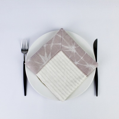 Prato branco com guardanapo duplo cinza e branco, talheres pretos