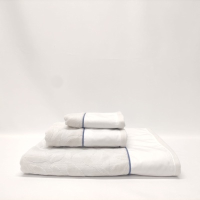 Conjunto de toalhas brancas empilhadas com linhas azuis