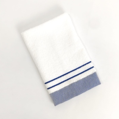 Toalha branca com riscos azuis e borda azul