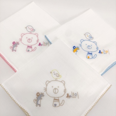 Três panos de boca brancos com bordados coloridos de gato, pássaro, macaco e palavra 'hello|'