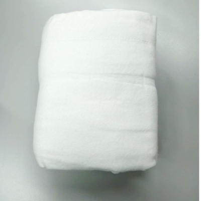 Toalha branca dobrada sobre superfície cinza clara