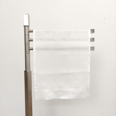 toalha branca pendurada em suporte metálico prateado