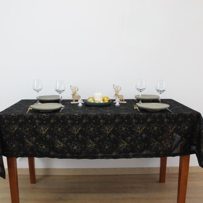 Mesa posta com toalha preta e decoração natalícia dourada