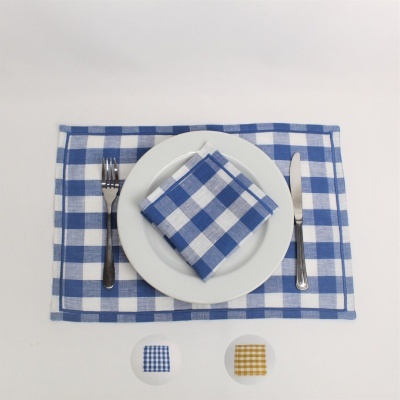 Jogo americano e guardanapo azul e branco quadriculado com prato e talheres