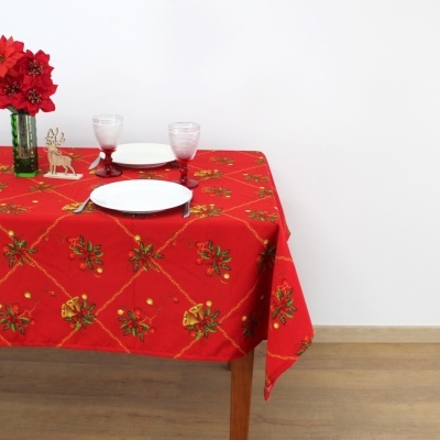 Toalha de mesa vermelha com padrão festivo, pratos, copos e decoração natalícia