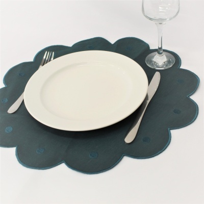 Jogo americano azul escuro com prato branco e talheres