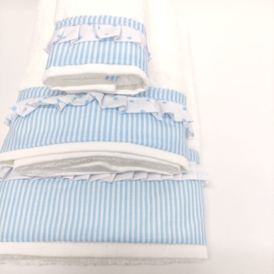 Conjunto de toalhas brancas com faixa azul e folhos em padrão de riscas e corações azuis