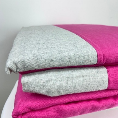 Tecido cinza claro e rosa vibrante empilhados sobre fundo branco