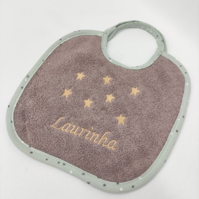 Babete cinzento com contorno verde e estrelas amarelas bordado com o nome Laurinha