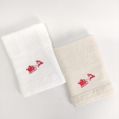 Duas toalhas de mão, branca e bege, com bordado vermelho de trenó e rena