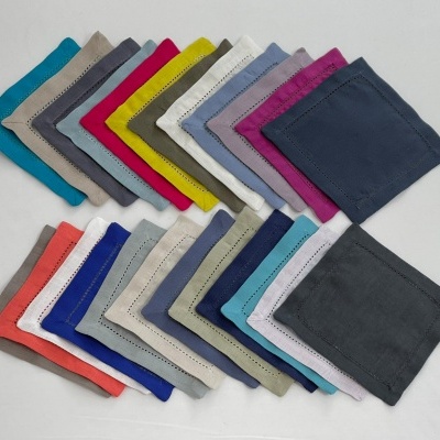 Paninhos ou lenços quadrados coloridos com bordas costuradas, organizados sobre fundo branco.