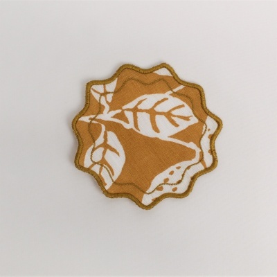 Guardanapo tecido castanho e branco com padrão de folhas