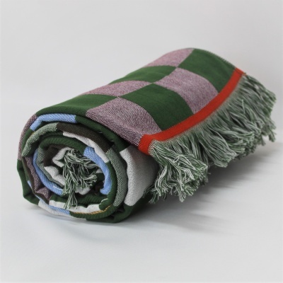 Cobertor ou manta xadrez colorida enrolada com franjas verdes