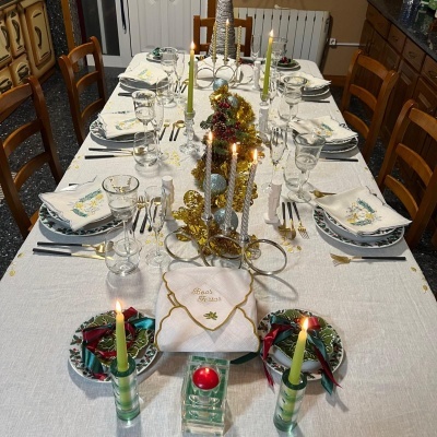 Mesa de jantar decorada com guardanapos, copos, velas e centro de mesa festivo