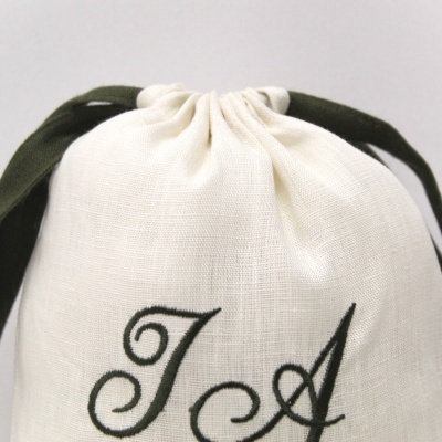Saco branco de tecido com cordão verde escuro e letras bordadas JA