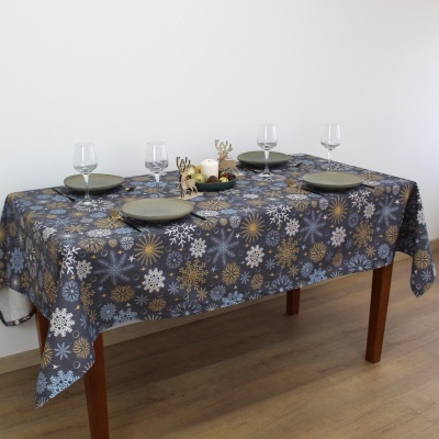 Mesa com toalha azul escura com flocos de neve e decoração de Natal