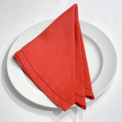 Guardanapo vermelho dobrado sobre prato branco