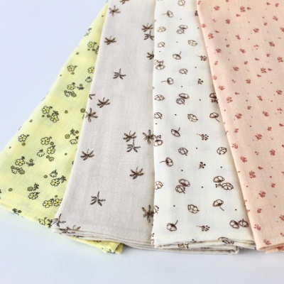 Tecidos algodão estampados com flores e folhas em amarelo, bege, branco e rosa