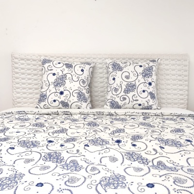 Conjunto de roupa de cama branco com padrão azul e cabeceira almofadada branca