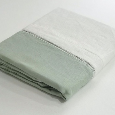Lençol dobrado branco com verde-acinzentado e faixa rendada