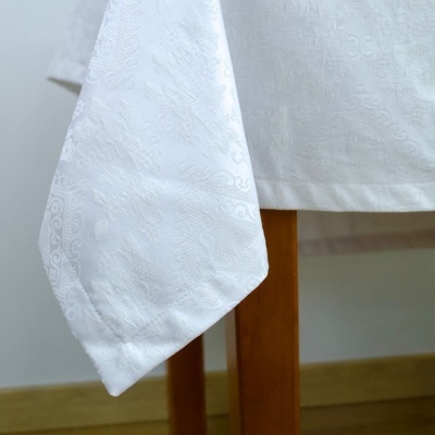 Guardanapo e toalha de mesa brancos com padrão bordado texturizado