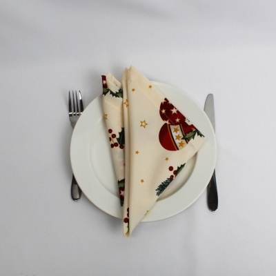 Guardanapo natalício em tecido sobre prato branco com talheres
