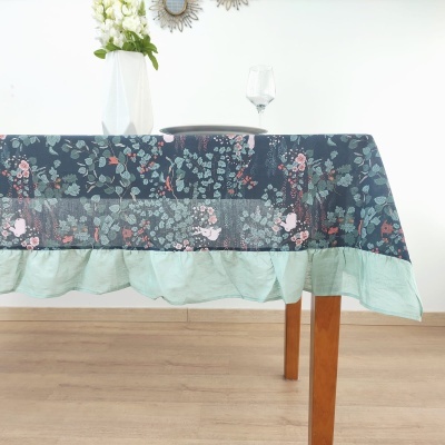 Toalha de mesa floral azul com barra verde em mesa de madeira