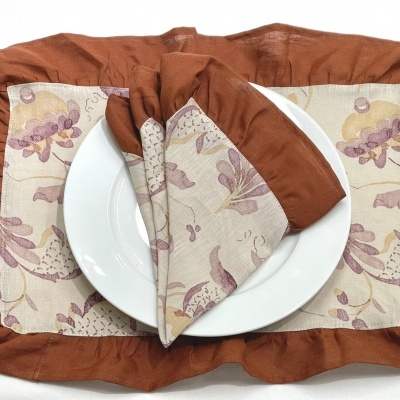 Conjunto de saco de tecido, guardanapo e prato em tom castanho e estampado com flores lilás.