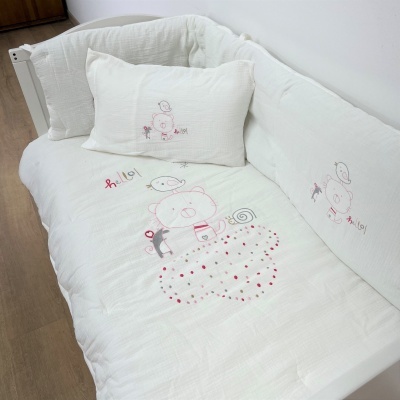 Berço branco com roupa de cama decorada com ursinhos cor de rosa