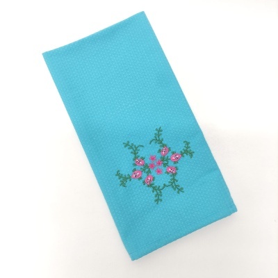 Pano de cozinha azul turquesa com bordado floral rosa e verde