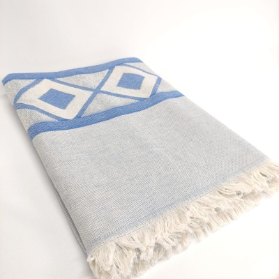 Toalha cinza clara com padrão azul e franjas brancas