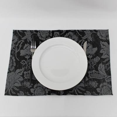 Conjunto mesa com prato branco, garfo e faca sobre base floral preta e cinza