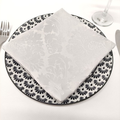 Prato decorado com guardanapo branco e talheres ao lado