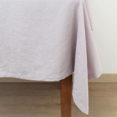 Toalha de mesa lilás pendurada em mesa de madeira