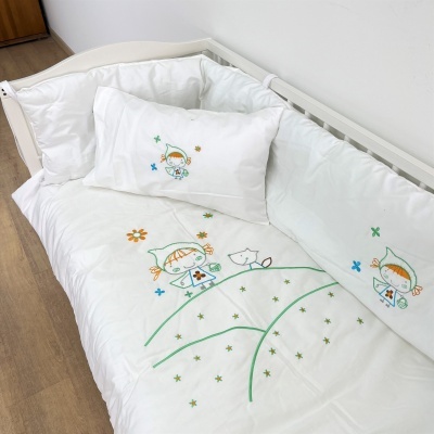 Roupa de cama branca com bordados infantis coloridos em cama de criança