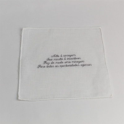 Pano branco com texto bordado a cinzento no centro