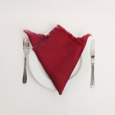 Jogo americano com guardanapo vermelho, prato branco, garfo e faca