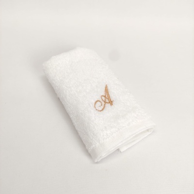 Toalha branca com letra A bordada em bege
