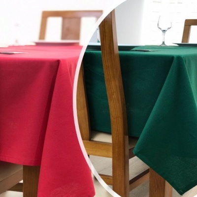 Duas toalhas de mesa, vermelha e verde, em mesas de madeira com cadeiras