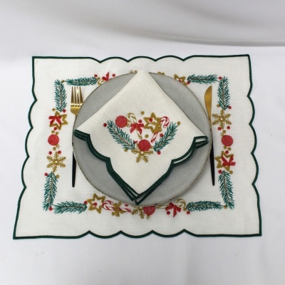 Jogo americano e guardanapo natalício bordados em tecido branco com motivos coloridos