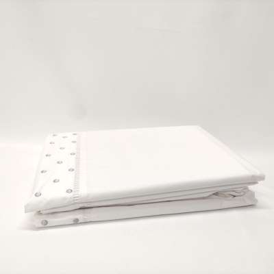 Lençol branco com padrão de pontos cinza na borda